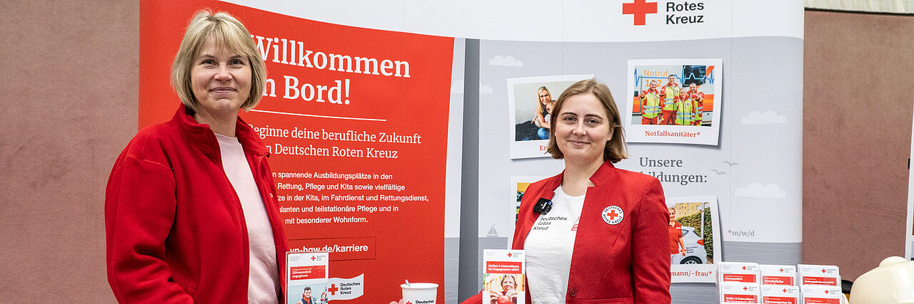 Zwei Rotkreuzlerinnen präsentieren das DRK bei einer Jobmesse.