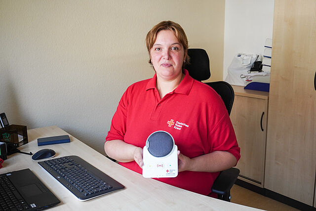 Mitarbeiterin stellt Hausnotruf-Gerät vor